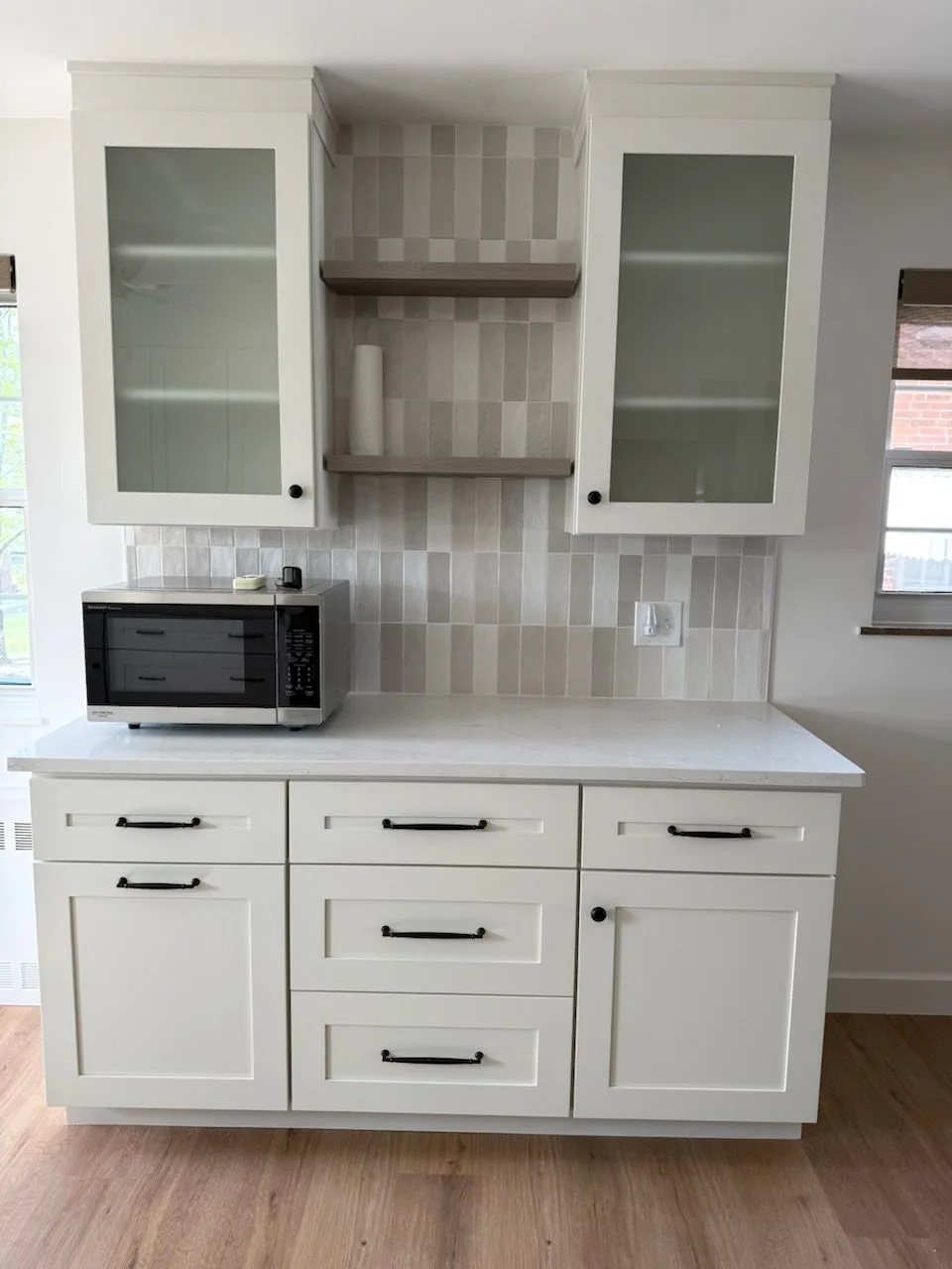 Custom stainless range hood with marble-look tile backsplash and white cabinetry in a Loveland, Ohio kitchen remodel